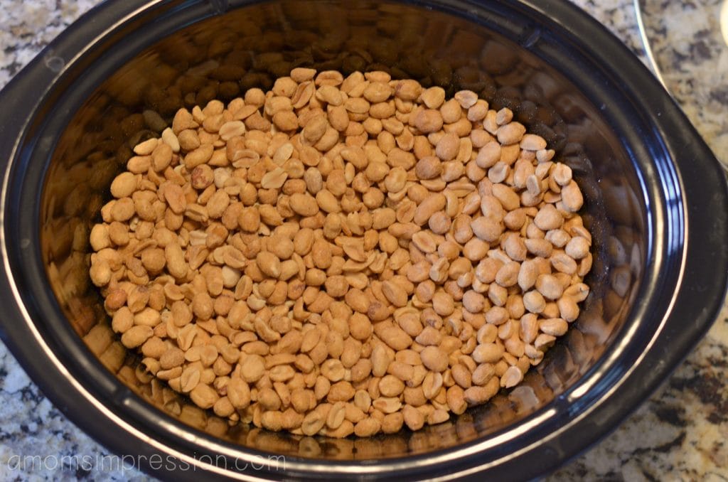 Start by putting peanuts into your slow cooker for this crockpot candy recipe