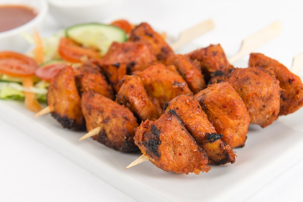 Pressure Cooker chicken skewers on a white plate with vegetables 