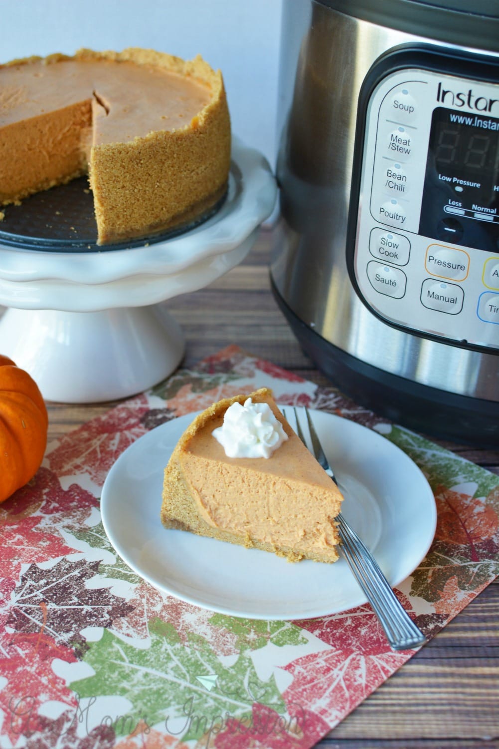 Instant Pot Cheesecake with pumpkin has a dollop of whipped cream on top. 