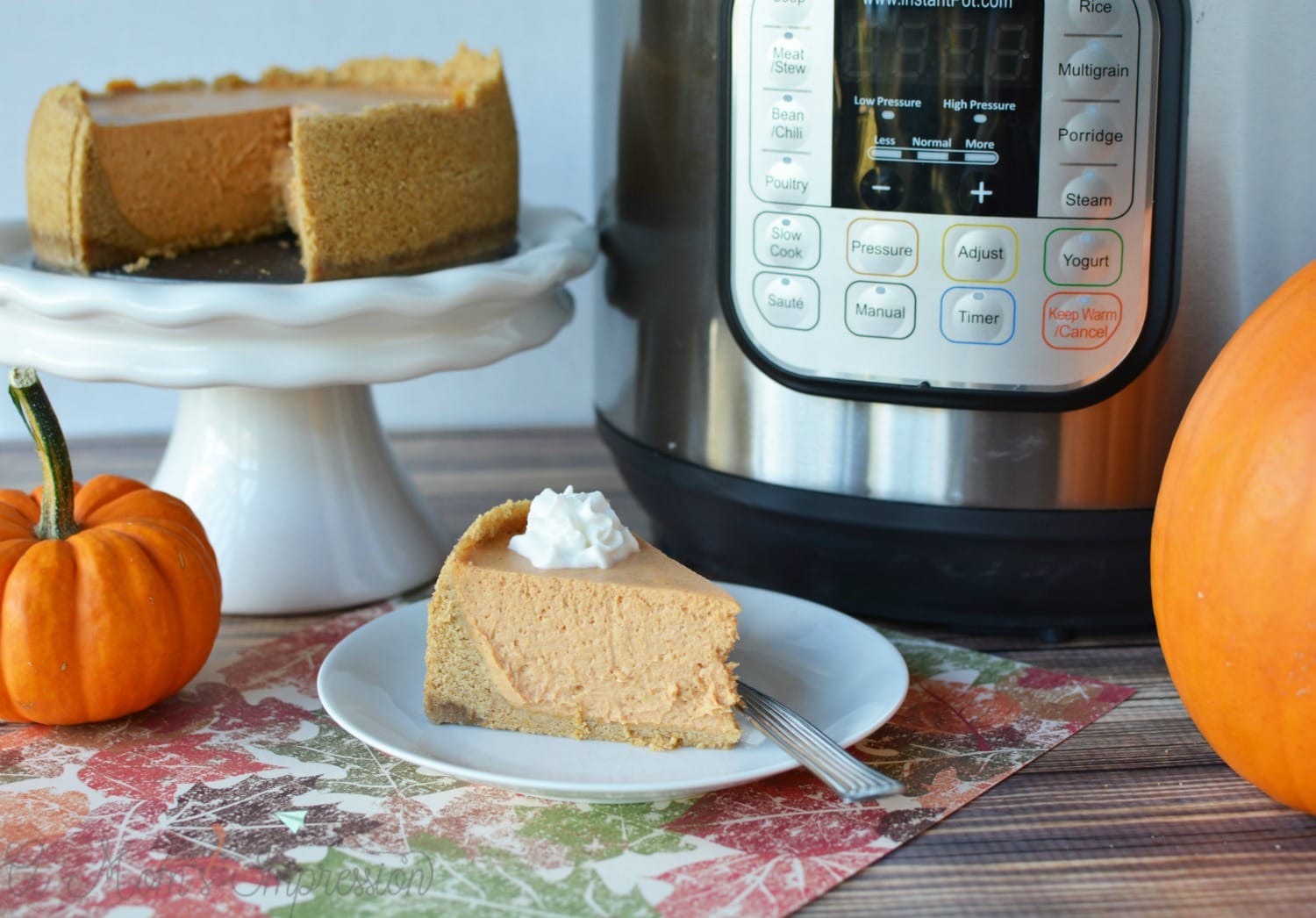 Instant Pot Pumpkin cheesecake sitting on a white plate with pumpkins.