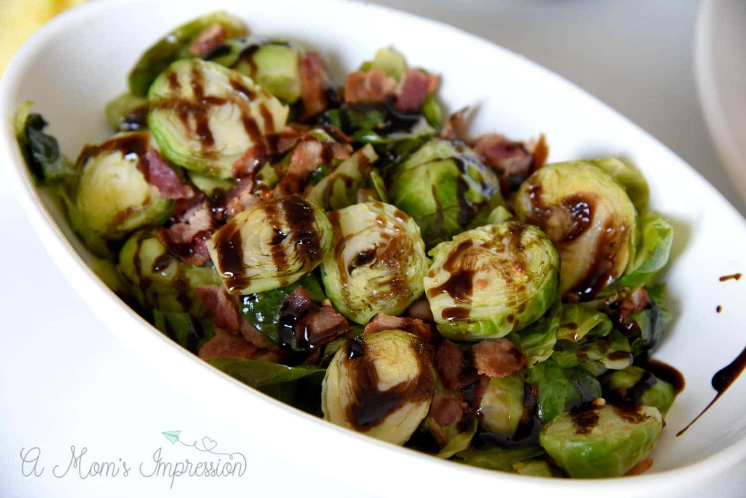 Bacon and Balsalmic Brussel Sprouts final dish in a white oval bowl