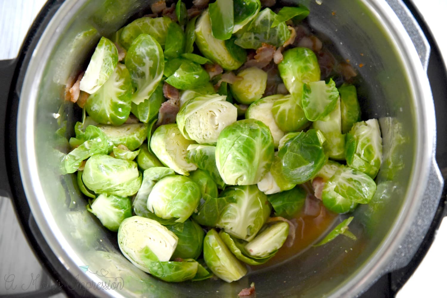 layering Brussel Sprouts in the Instant Pot with bacon and chicken stock. 