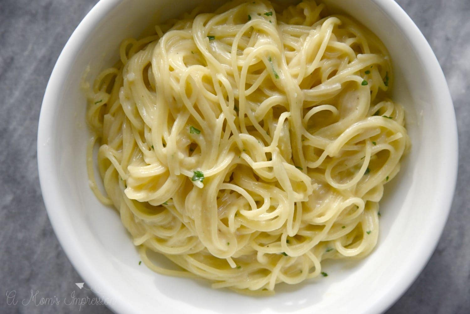 Easy garlic parmesan noodles in a white bowl on top of a marble table top