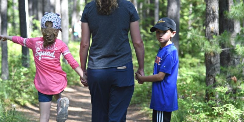 a mom, son and daughter hiking in the woods