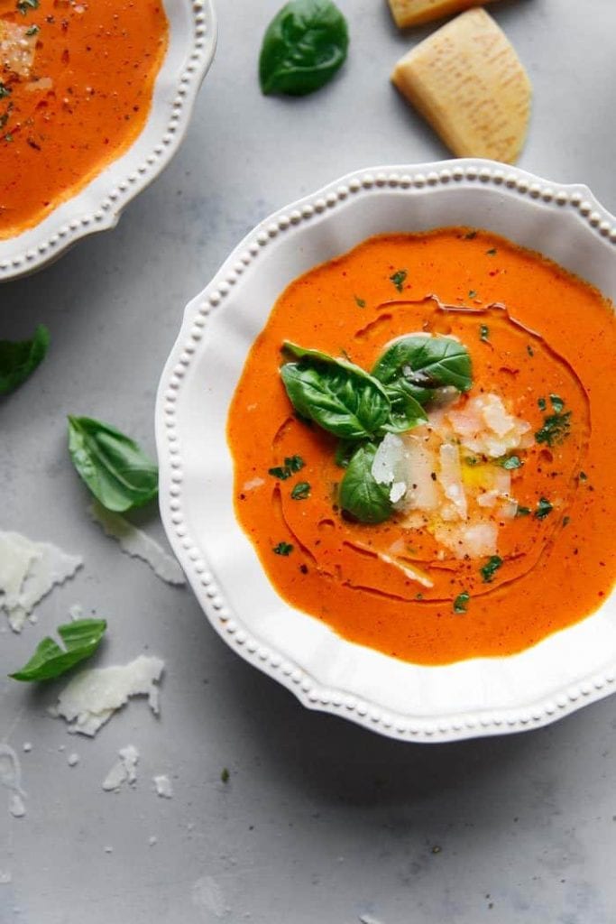 instant pot homemade-tomato-soup in a white bowl on a table with basil