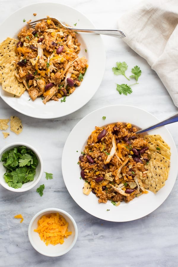 two plates of southwestern chicken and riceon a white table