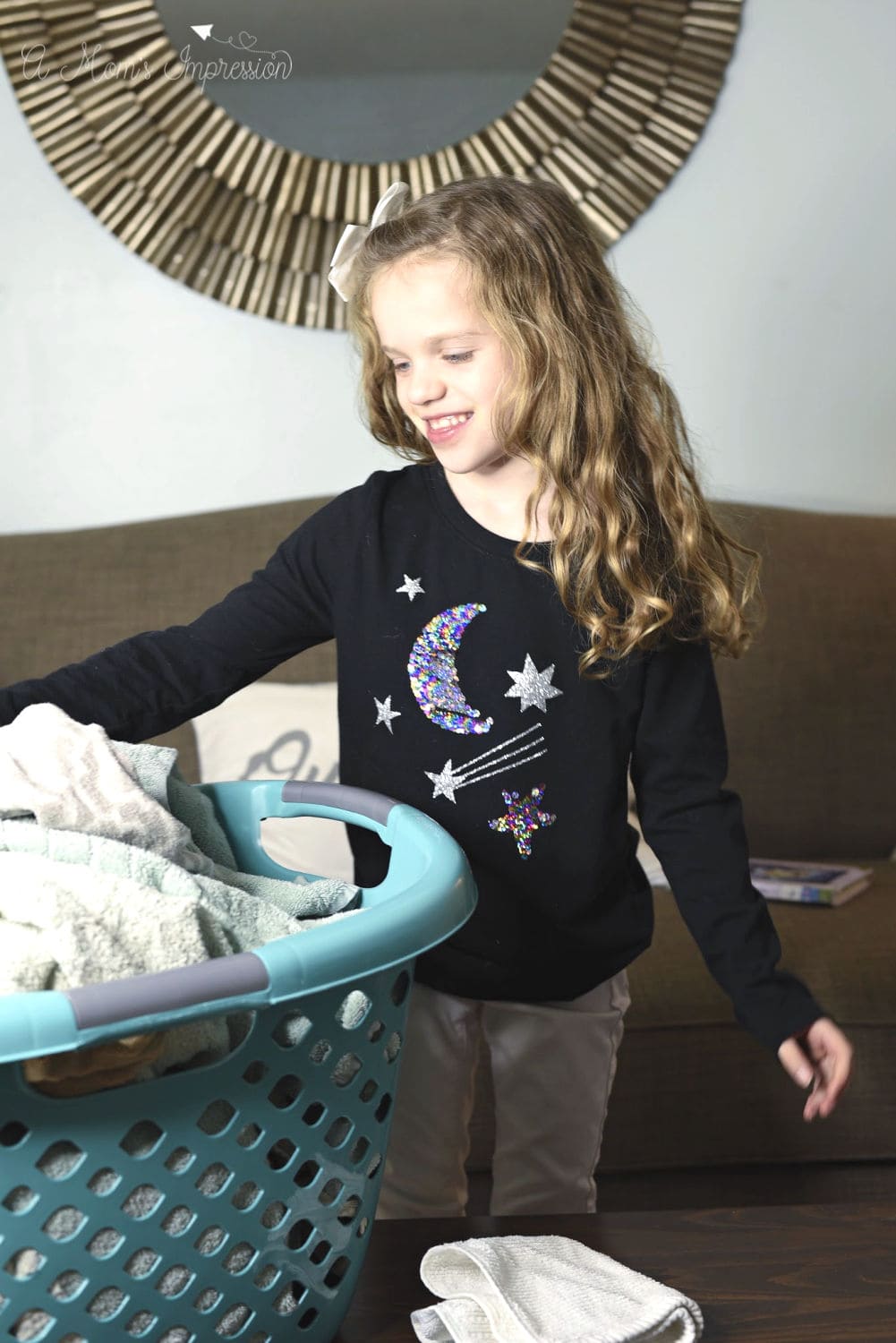 A child Folding Clothes out of a laundry basket