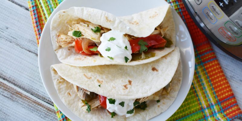 Instant Pot Chicken Fajitas served next to a pressure cooker for dinner.