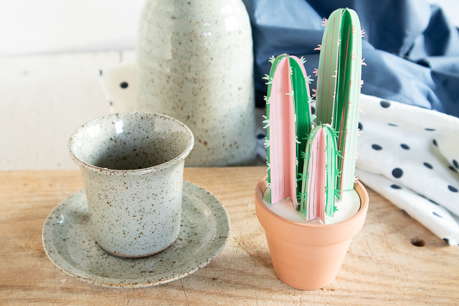 a paper cactus craft sitting on a bedside table