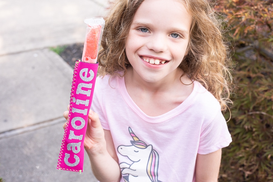 a girl holding an ice pop koozie