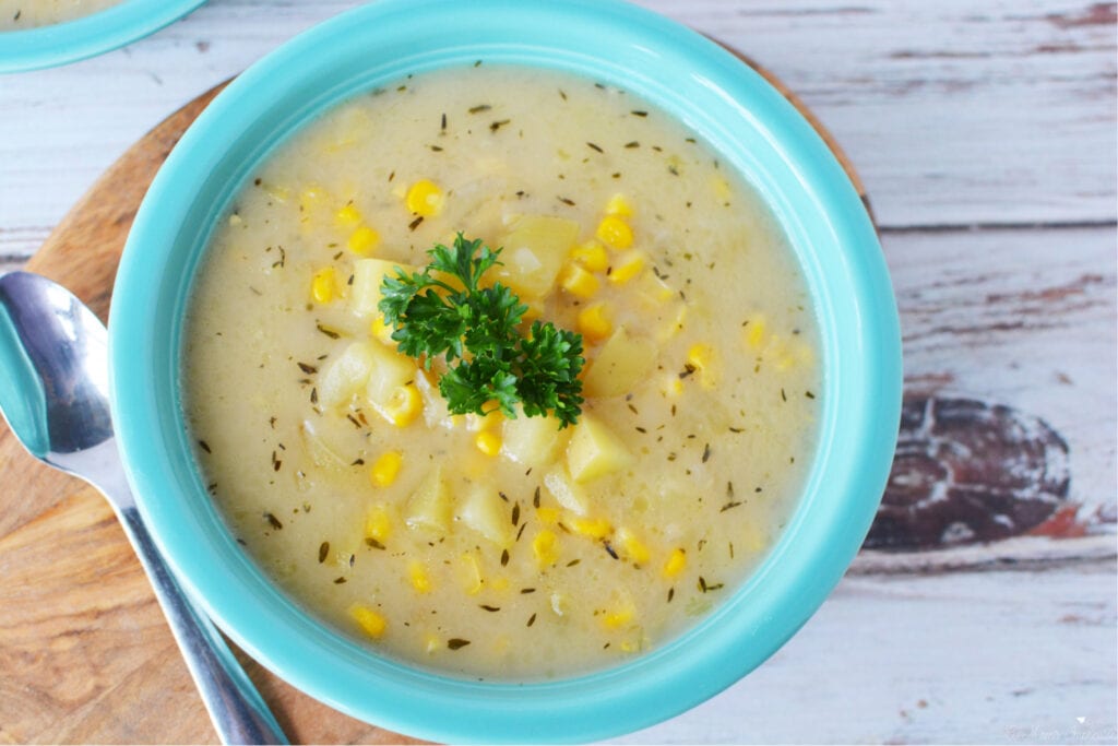 Instant Pot Corn Chowder being served in a blue bowl for dinner.