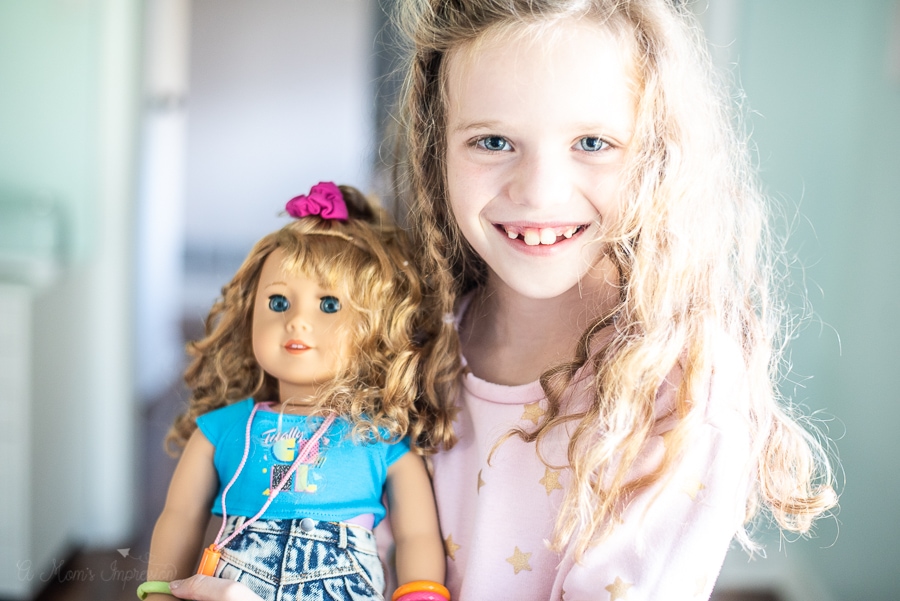 A girl holding am 80's themed doll