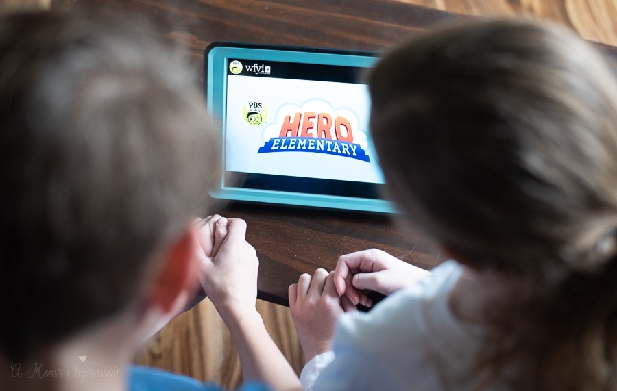 two kids watching hero elementary on an iPad