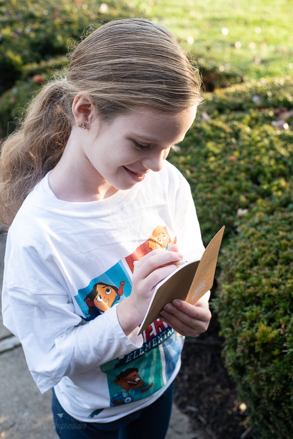 a girl writing something down in her notebook