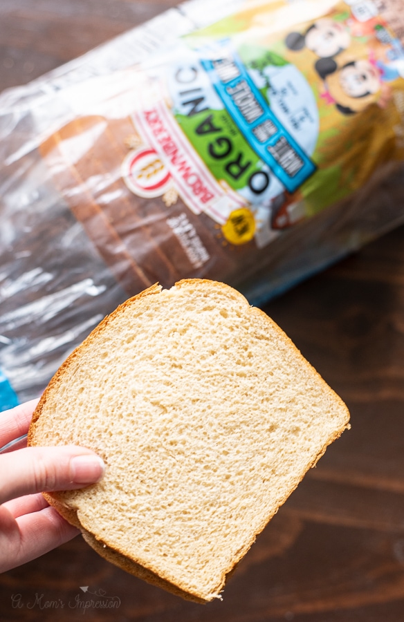 a person holding a piece of wheat bread