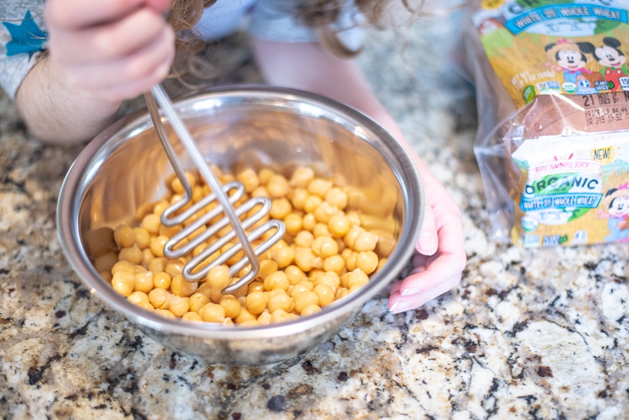 smashing chickpeas with a potato masher