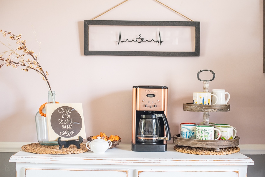 A custom coffee bar set up with coffee mugs, a coffee machine and custom signs