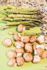 asparagus and mushrooms on a cutting board
