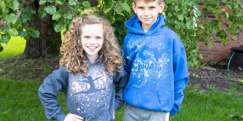 Two kids wearing custom hoodies with a bleached design on them