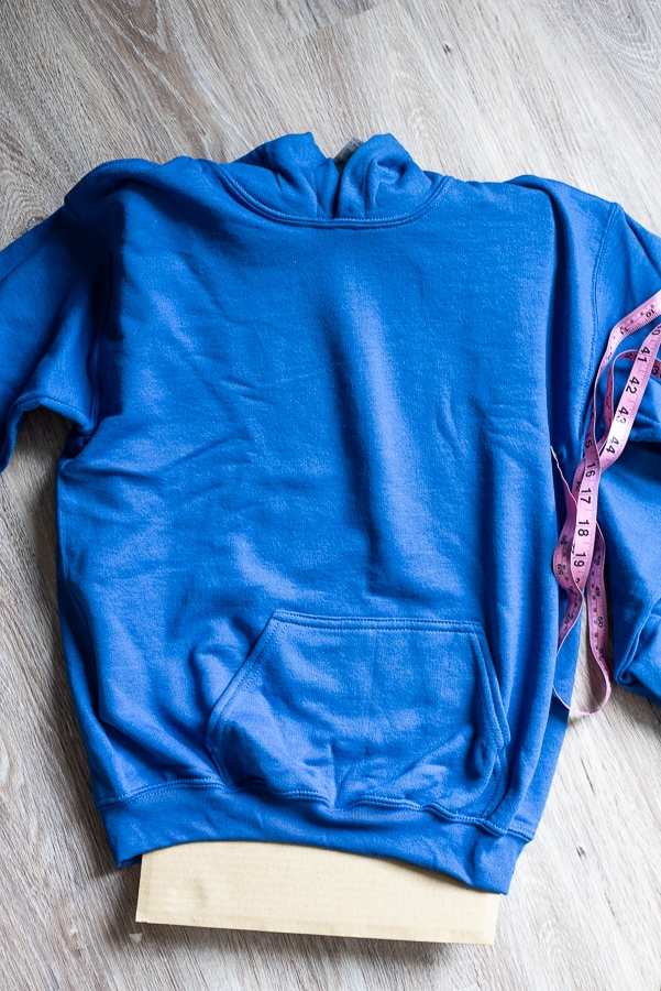 a blue hoodie with a pink tape measure