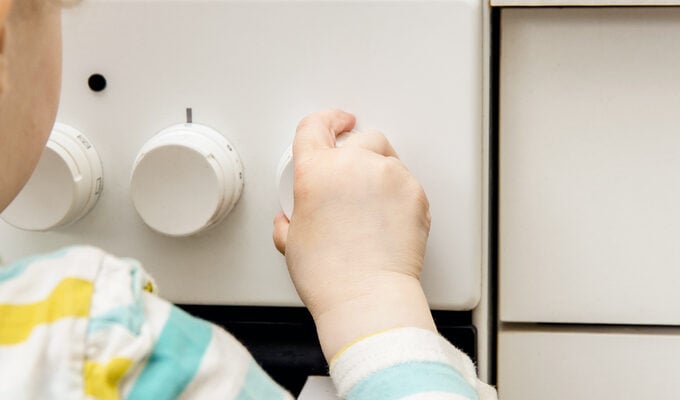 A child trying to turn on the oven